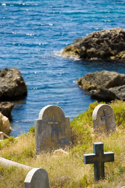 Old graveyard next to the water edge, rocks and sea of Malta — Stock Photo, Image