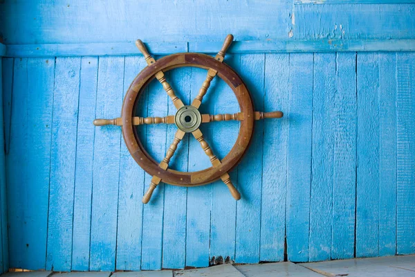 Blue wall, superannuated, old wooden steering of a vessel