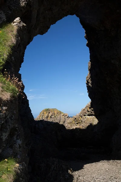 Formação única de rochas, caverna e céu azul, costa de Antrim, Irlanda do Norte — Fotografia de Stock