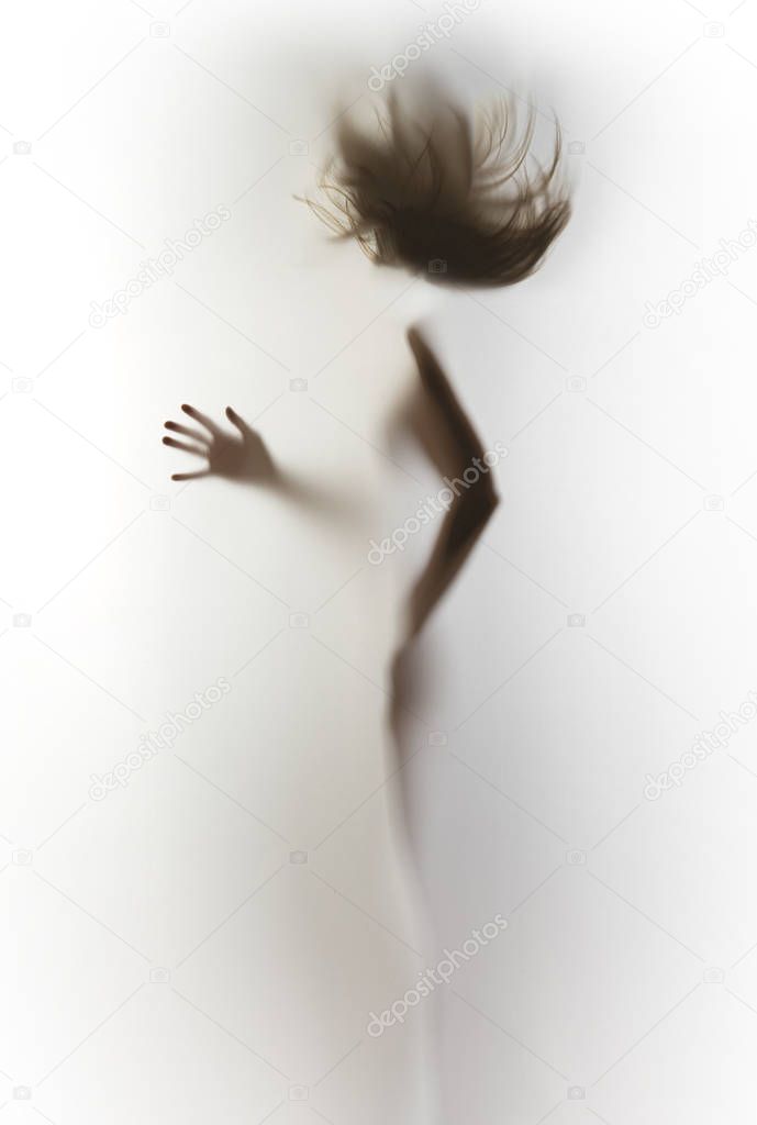 Silhouette of a slim, human body of a woman, flying hair, hand, fingers.