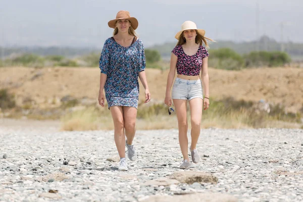 Twee Mooie Meisjes Stro Hoed Lopen Langs Een Strand Cyprus — Stockfoto