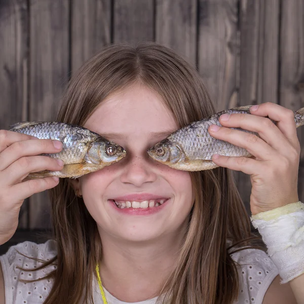 肖像年轻女孩和干鱼，关闭 — 图库照片