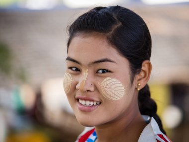 Portre genç Myanmar kızla thanaka gülümseme yüzünde mutluluk var. Burma