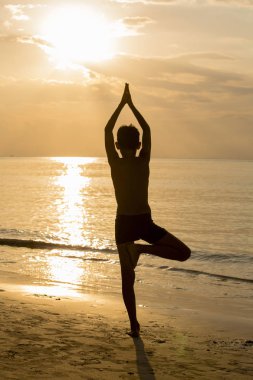 Yoga adam siluet, gün batımında pozlar üzerinde çalışıyor