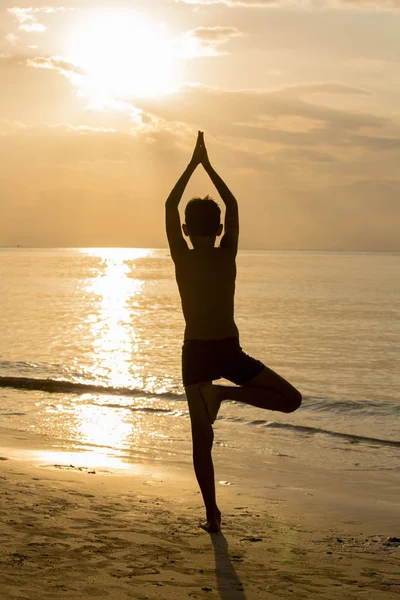 Yoga guy silhouette, working on poses at sunset — Stock Photo, Image