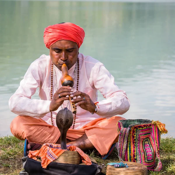 Portret snake charmer dorosłego człowieka w turbanie i cobra siedzi w pobliżu jeziora. Pokhara, Nepal — Zdjęcie stockowe