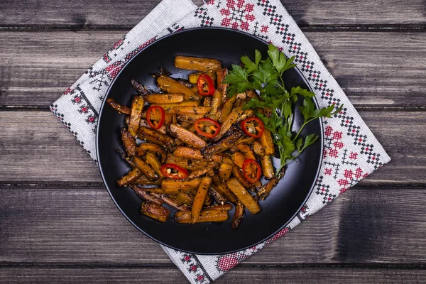 Roasted carrots in black plate, close up — Stock Photo, Image