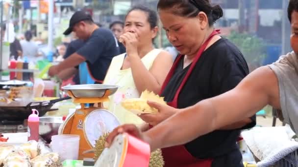 Thailändischer Straßenhändler schneidet einen Durian in Stücke, um ihn auf dem Nachtmarkt in Koh Phangan, Thailand, zu verkaufen. Nahaufnahme — Stockvideo