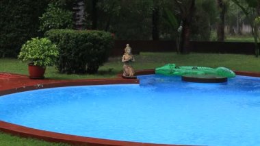 Tropikal yaz yağmuru büyük yağmur düşen Yüzme Havuzu ile Tayland tropikal ağaçlar üzerinde düşer