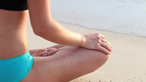 Yoga vrouw in ochtend op strand aan zee een vrouw in yoga lotus meditatie positie voorzijde zee bij zonsopgang vergadering. Gezonde actieve levensstijl concept — Stockvideo