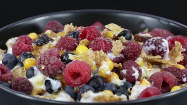 Cereal flakes with blueberries, raspberries and sea buckthorn rotating . Crunchy muesli food background close-up. Cereals, berry and dried food mixed for breakfast . — Stock Video