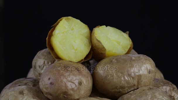 Batatas assadas. Batata em um fundo preto gira, close-up — Vídeo de Stock