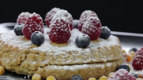 Cake with raspberries, blueberries, sea buckthorn sprinkled with powdered sugar — Stock Video