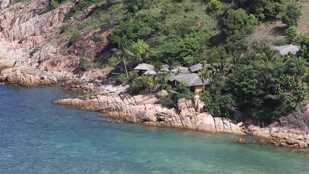 Tropical bungalow on a rocky beach next to the blue sea water. Koh Phangan , Thailand — Stock Video