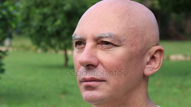 Portret Kaukasische oude man op de achtergrond van de natuur, close-up — Stockvideo