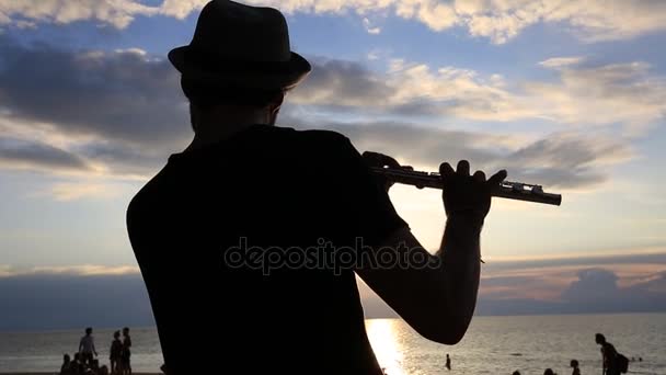 L'uomo suona il flauto al tramonto sulla spiaggia durante una festa di luna piena sull'isola Koh Phangan, Thailandia — Video Stock