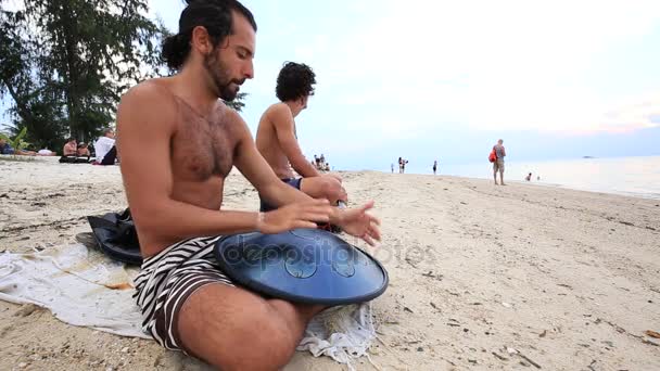 Mannen spelen een instrument genaamd ' ' hang ' ' of ' ' Hang Drum ' ' bij zonsondergang op het strand tijdens een vollemaanfeest op het eiland Koh Phangan, Thailand — Stockvideo