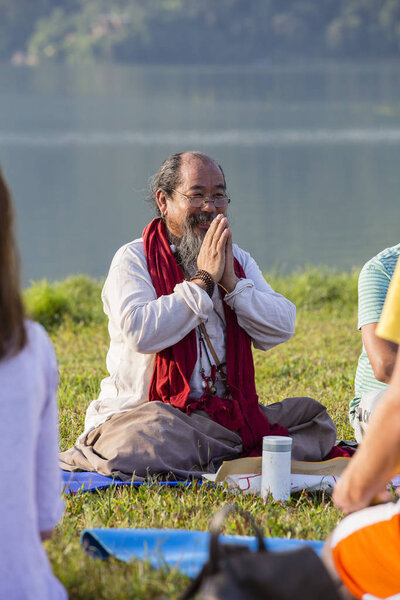 Тибетский лама проводит занятия с солнечными серферами по медитации и йоге. Pokhara, Непал
