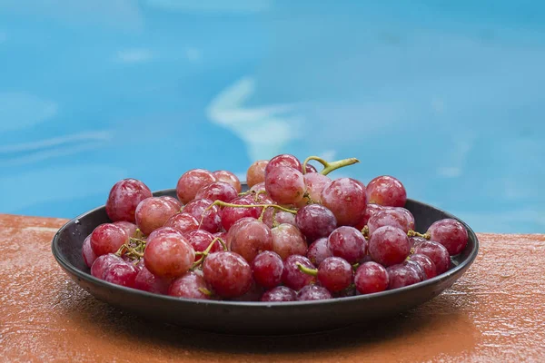 Ripe red grape near swimming pool — Stock Photo, Image