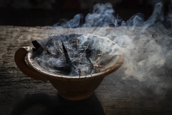 Vapeur tasse d'argile avec des épices sur table en bois dans la rue. Nature morte fond noir, Népal . — Photo