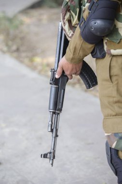 Savaşçı bir Kalaşnikof saldırı tüfeği tutan
