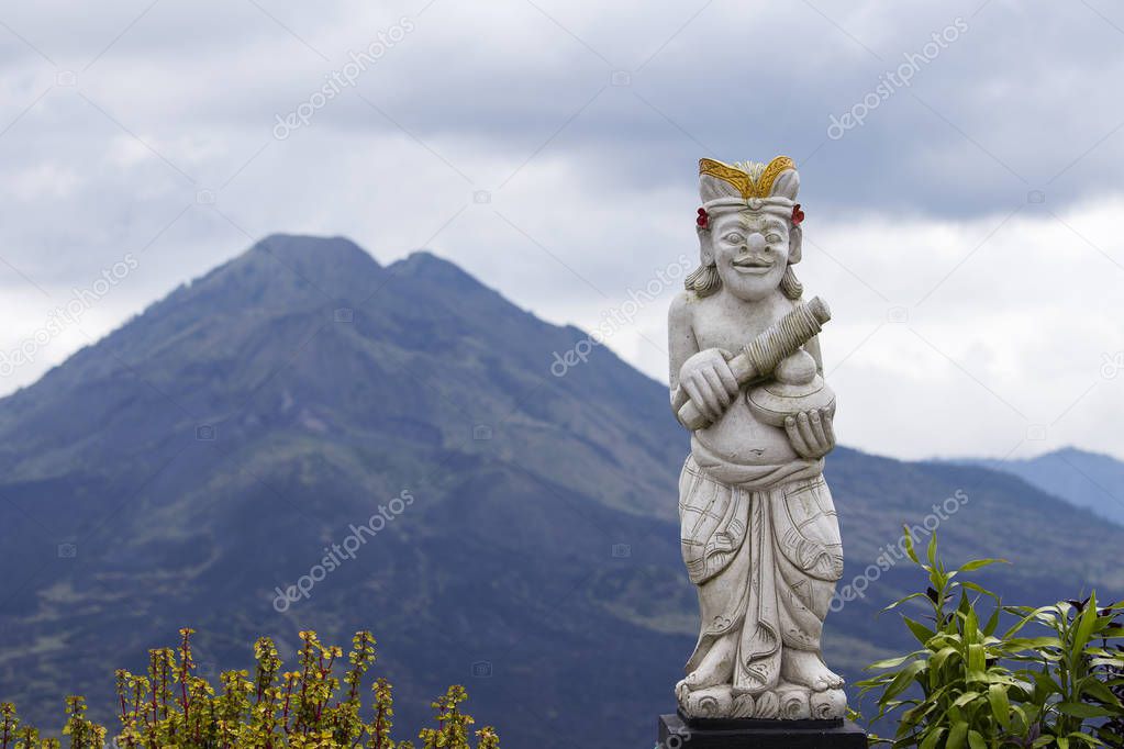 Balinese sculpture and landscape of Batur volcano on Bali island, Indonesia