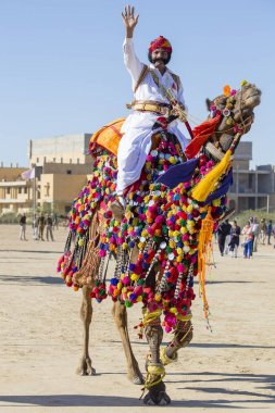 Geleneksel Rajasthani elbise giyen deve ve Hint erkek Jaisalmer, Rajasthan, Hindistan çöl Festivali olarak Bay Desert yarışmaya katılmak