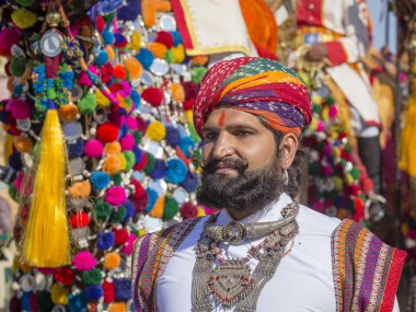 Geleneksel Rajasthani elbise giyen deve ve Hint erkek Jaisalmer, Rajasthan, Hindistan çöl Festivali olarak Bay Desert yarışmaya katılmak
