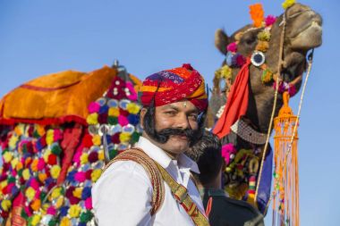 Geleneksel Rajasthani elbise giyen deve ve Hint erkek Jaisalmer, Rajasthan, Hindistan çöl Festivali olarak Bay Desert yarışmaya katılmak