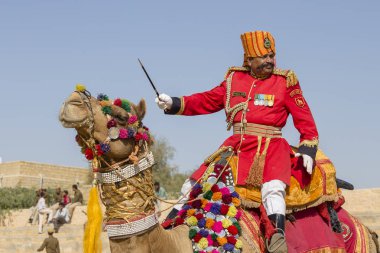 Geleneksel Rajasthani elbise giyen deve ve Hint erkek Jaisalmer, Rajasthan, Hindistan çöl Festivali olarak Bay Desert yarışmaya katılmak