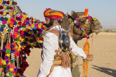 Geleneksel Rajasthani elbise giyen deve ve Hint erkek Jaisalmer, Rajasthan, Hindistan çöl Festivali olarak Bay Desert yarışmaya katılmak