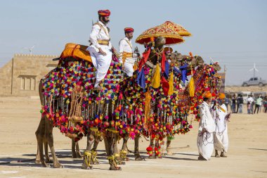 Geleneksel Rajasthani elbise giyen deve ve Hint erkek Jaisalmer, Rajasthan, Hindistan çöl Festivali olarak Bay Desert yarışmaya katılmak