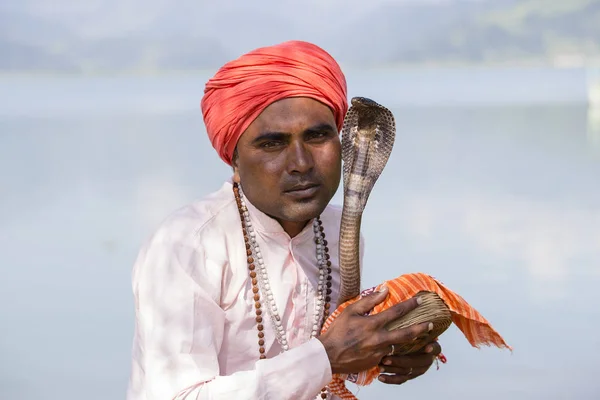 Porträt Schlangenbeschwörer erwachsener Mann in Turban und Kobra am See sitzend. pochara, nepal — Stockfoto