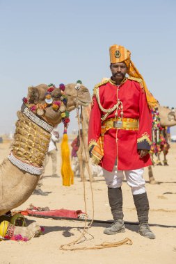 Geleneksel Rajasthani elbise giyen deve ve Hint erkek Jaisalmer, Rajasthan, Hindistan çöl Festivali olarak Bay Desert yarışmaya katılmak