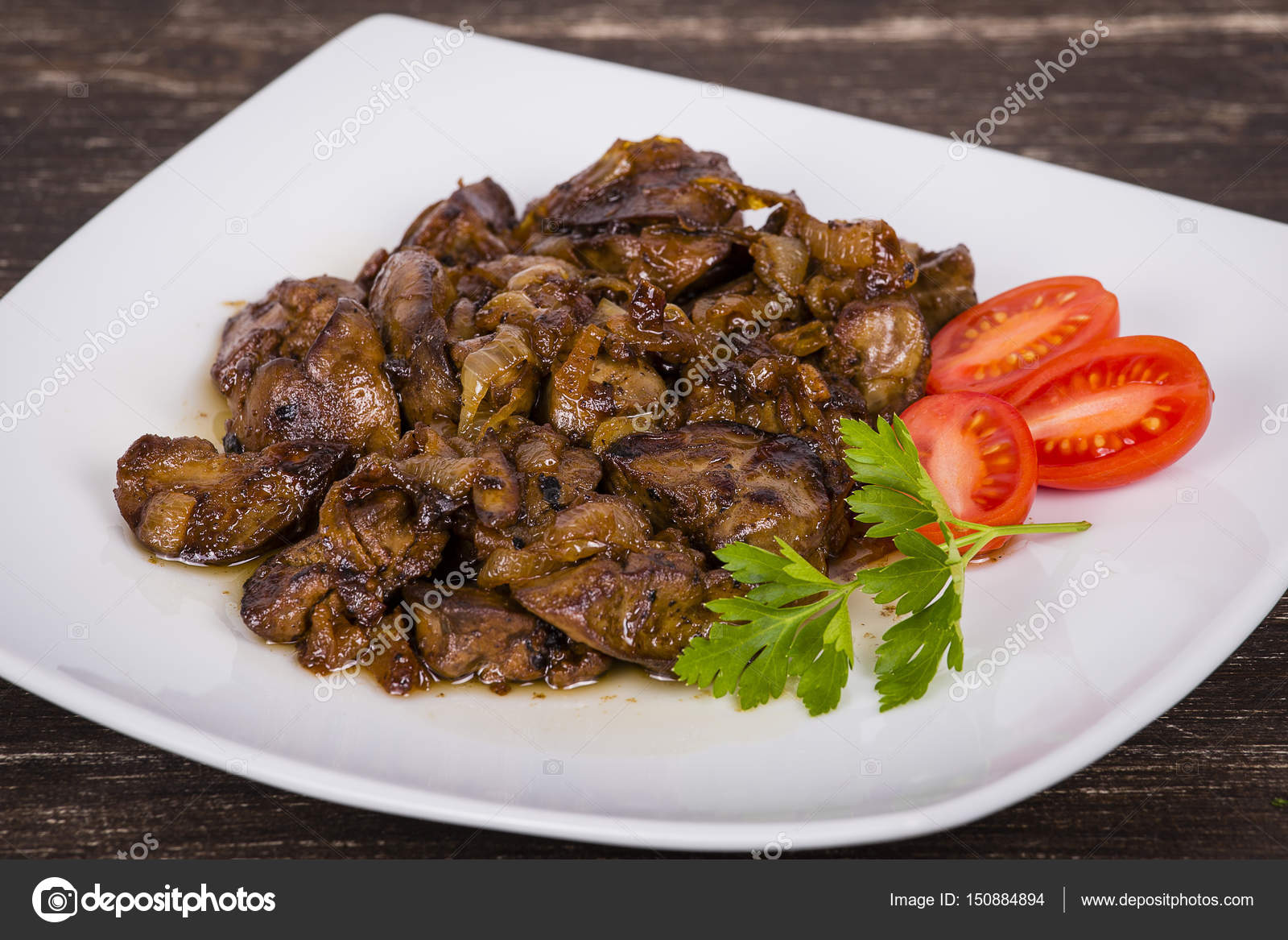 Chicken livers in a creamy sauce with onion on white plate Stock Photo