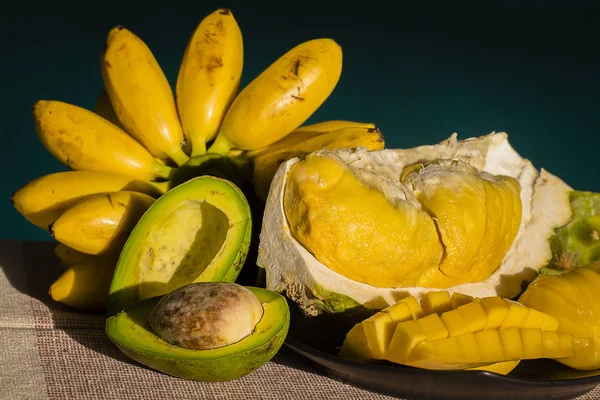 Banán, avokádo, durian a mango na stole jsou slunečné počasí. — Stock fotografie