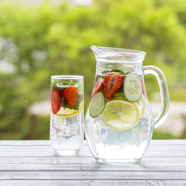 Boisson diététique de désintoxication avec jus de citron, fraise rouge, concombre et feuilles de menthe dans de l'eau claire glacée . — Photo