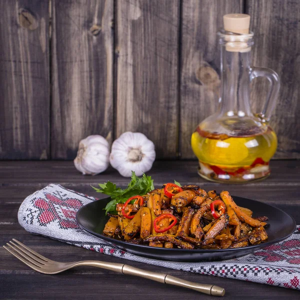 Roasted carrots in black plate, close up — Stock Photo, Image