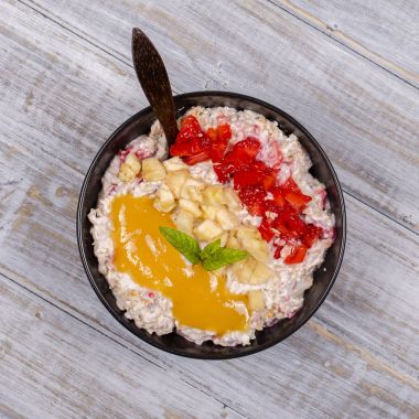 Tatlım kırmızı çilek, muz, chia tohumu, yulaf gevreği, yapılan ve yoğurt ile giyinmiş müsli