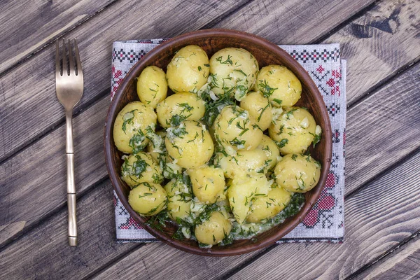 Dereotu, sarımsak ve ahşap masa bir tabağa tereyağı haşlanmış patates