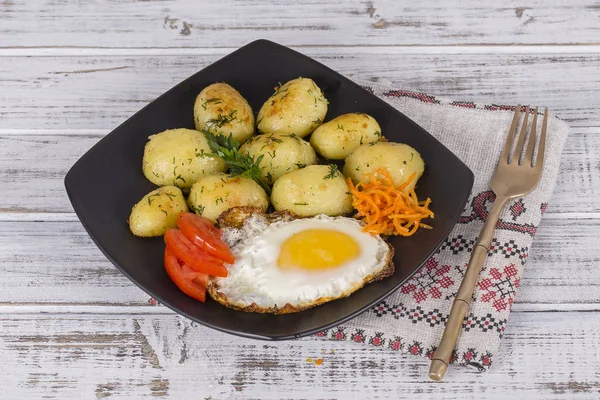 Batatas jovens cozidas com ovos fritos, cenoura e tomate. Fechar — Fotografia de Stock
