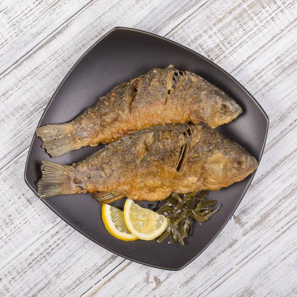 Fried fish crucian on wooden table background — Stock Image Fried fish crucian on wooden table background Stock Photo