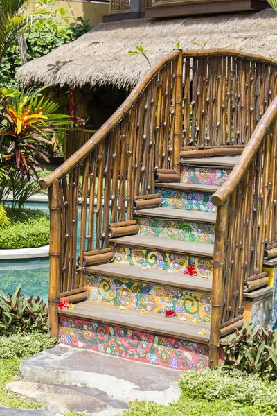 Colorido puente de madera en un jardín tropical junto a la piscina. Bali, Indonesia —  Fotos de Stock