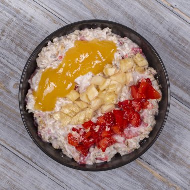 Tatlım kırmızı çilek, muz, chia tohumu, yulaf gevreği, yapılan ve yoğurt ile giyinmiş müsli