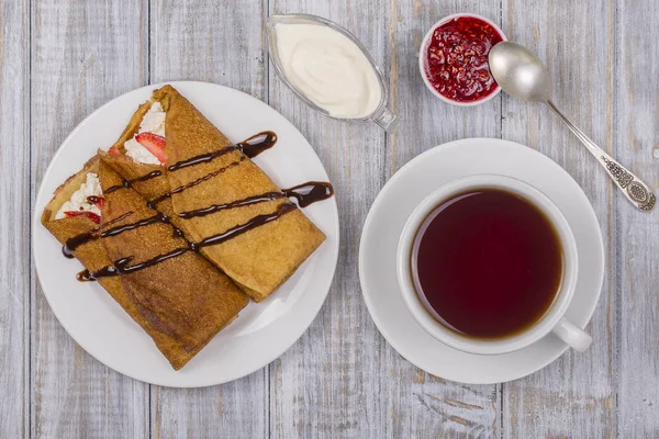 Pfannkuchen mit Quark und Tasse grünem Tee auf dem Holztisch — Stockfoto