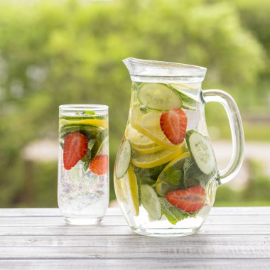 Diyet Detoks içecek temiz su buz ile limon suyu, kırmızı çilek, salatalık ve nane yaprakları ile.