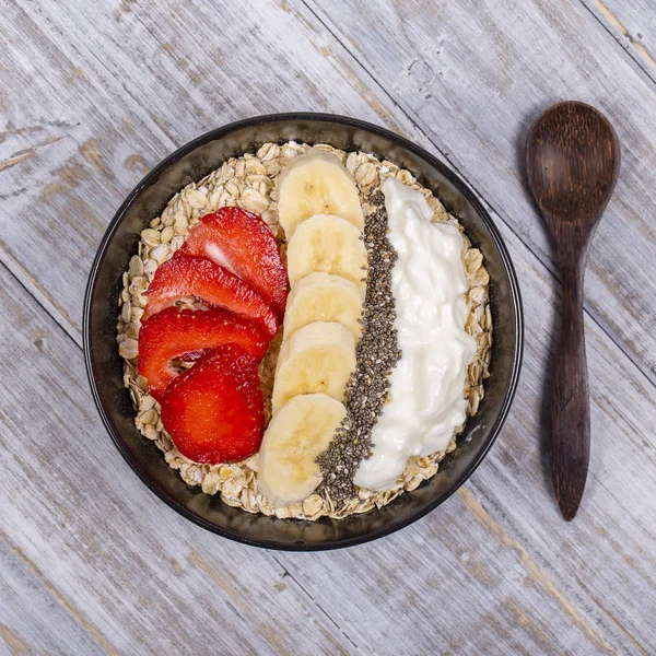 Muesli gemaakt van rode aardbeien, banaan, chia zaden, Haver vlokken, honing en gekleed met yoghurt — Stockfoto