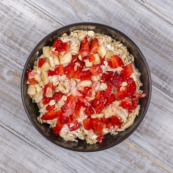 Muesli hecho de fresas rojas, plátano, semillas de chía, copos de avena, miel y aderezado con yogur — Foto de Stock