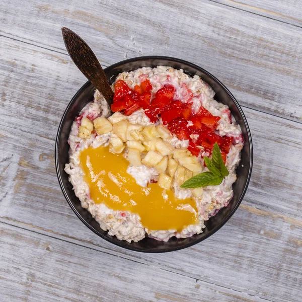 Muesli feito de morangos vermelhos, banana, sementes de chia, flocos de aveia, mel e vestido com iogurte — Fotografia de Stock