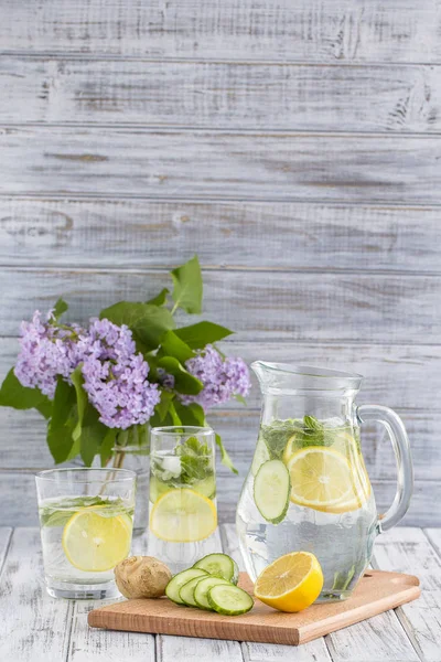 Boisson diététique de désintoxication avec jus de citron, gingembre, concombre et feuilles de menthe dans de l'eau claire avec glace . — Photo